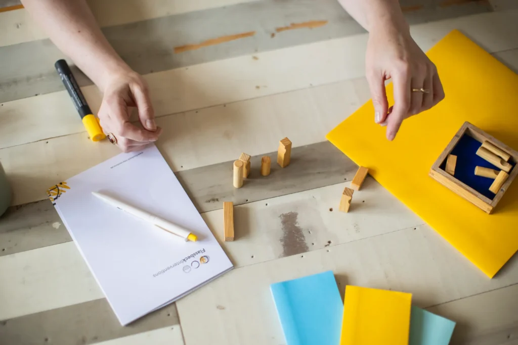 Visualisierung eines Entscheidungsprozesses im Unternehmen mit Holzfiguren und Moderationsmaterial